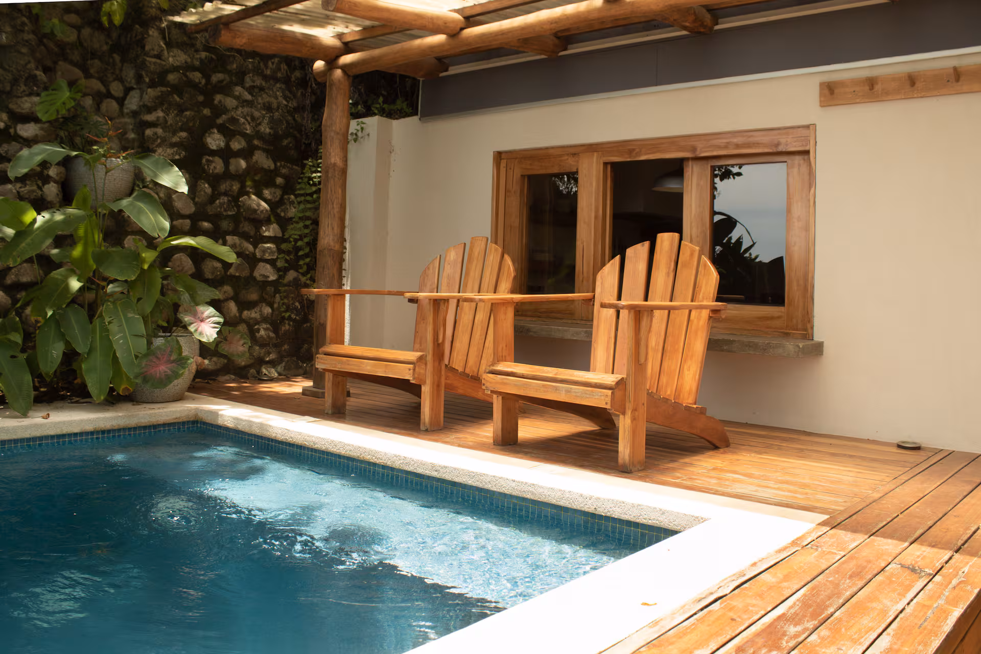 Stone stairs leading down to the infinity pool, framed by jungle