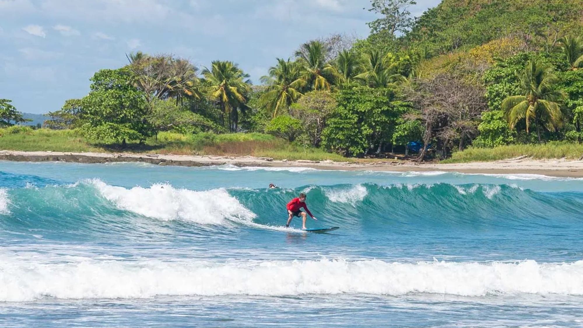 Surfer on a clean Pacific wave off Playa Santa Teresa at dawn